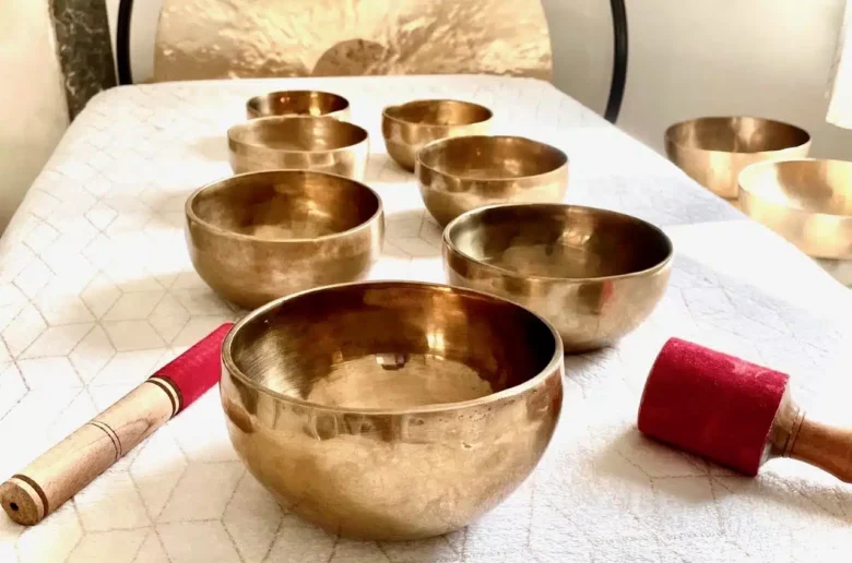 Table de massage sonore avec bols tibétains disposés