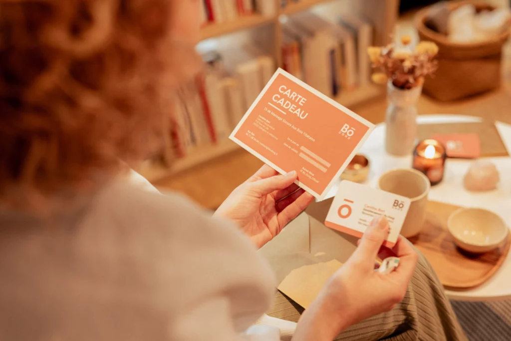 Mains tenant un coffret cadeau bien-être dans une lumière chaleureuse