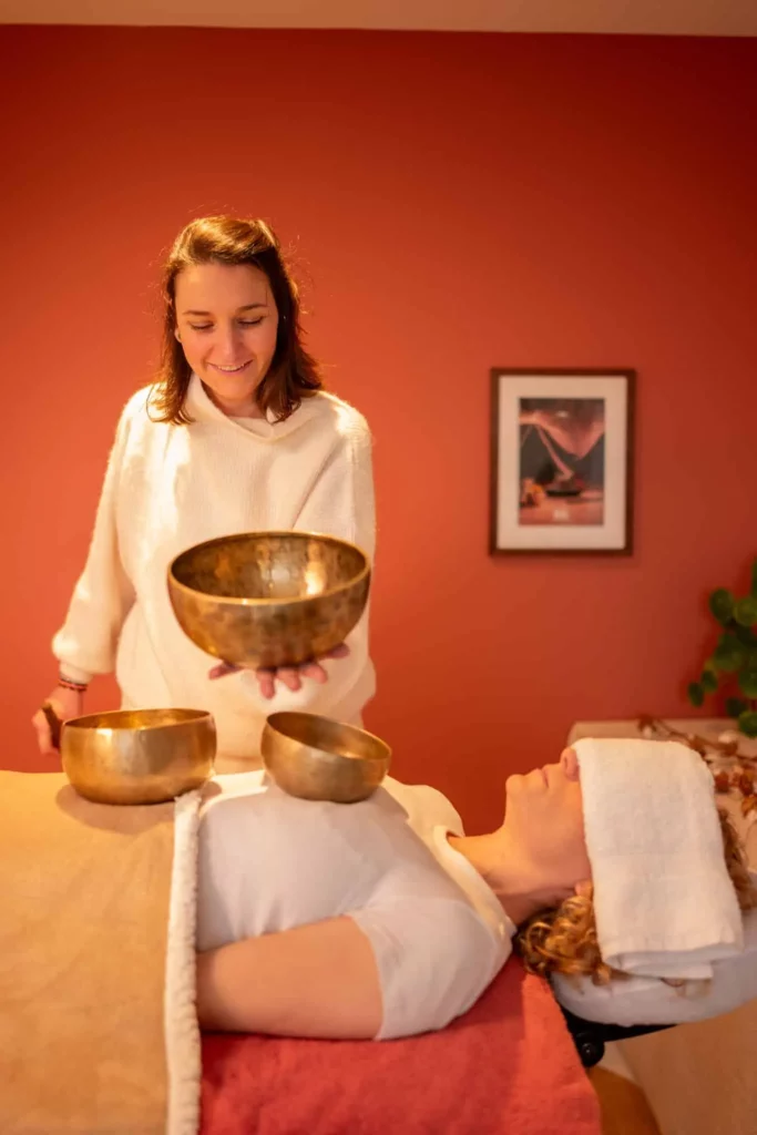 Massage sonore aux bols tibétains – Bo-DONG Caroline, praticienne chez Bo-DONG, effectue un massage sonore avec des bols tibétains sur une cliente allongée pour favoriser la détente et l'harmonie intérieure.